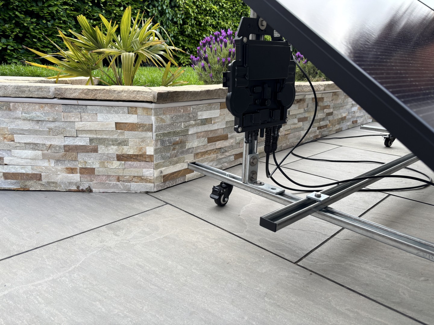 Microinverter mounted behind ground mounted solar panel